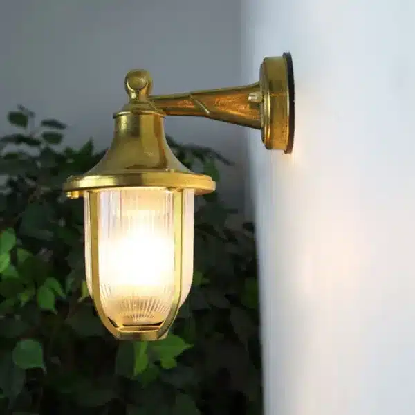 Brass down coastal outdoor wall light side view illuminated
