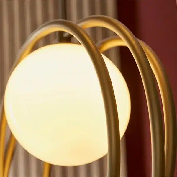 Brushed gold pendant light with opal glass shade close up