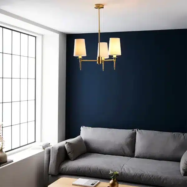 Satin brass pendant light with white fabric shades in living room