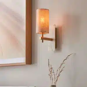 Modern brass and marble effect wall light mounted facing upward with linen shade