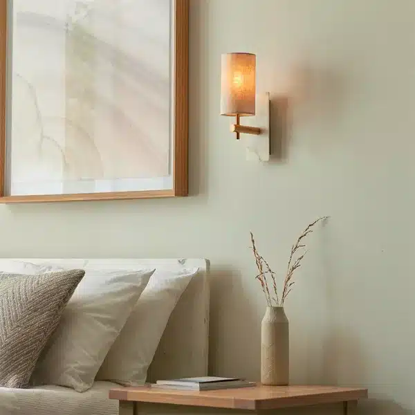 Modern brass and marble effect wall light mounted facing upward in bedroom