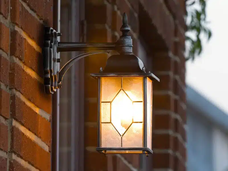 Italian-style outdoor wall lantern with frosted glass installed at house entrance