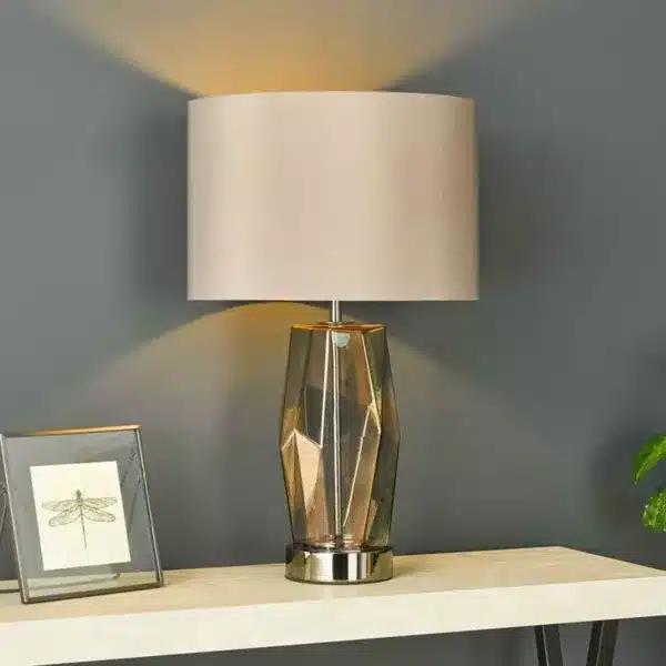 Smoked glass touch table lamp styled in a modern room setting